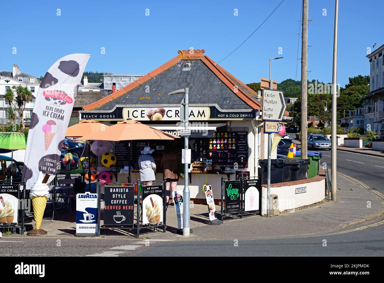 Tourists relaxing at an ice cream parlour along the seafront, Sidmouth, Devon, UK, Europe. Stock Photo