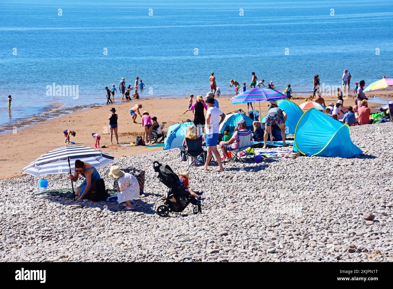 Tourists relaxing on the beach with the sea to the rear, Sidmouth, Devon, UK, Europe. Stock Photo