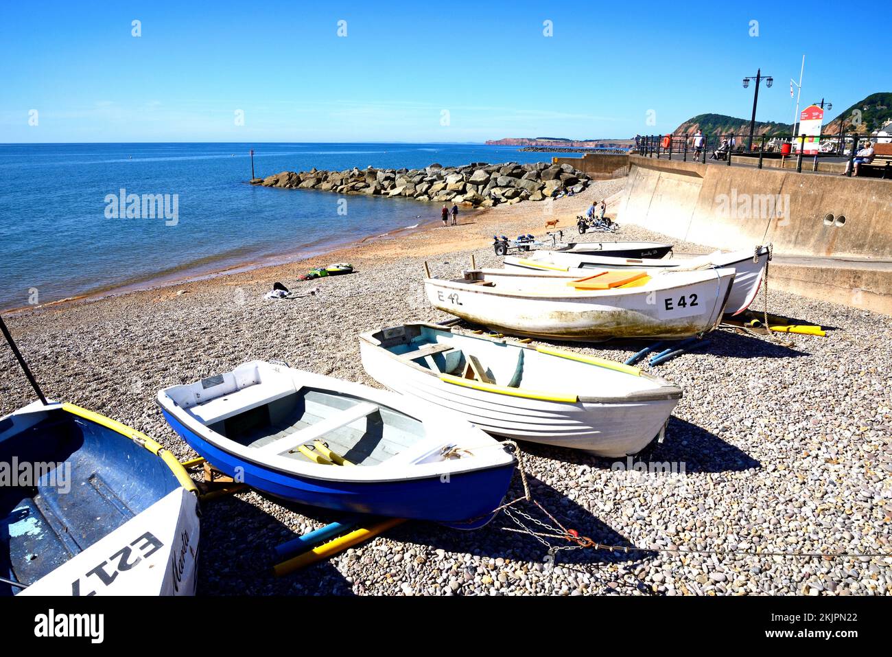 Small boats moored on the beach with views towards the promenade and cliffs, Sidmouth, Devon, UK, Europe. Stock Photo