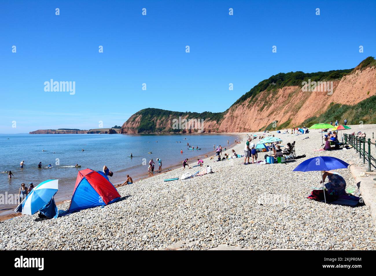 Tourists relaxing on Jacobs Ladder beach with views towards the cliffs, Sidmouth, Devon, UK, Europe. Stock Photo