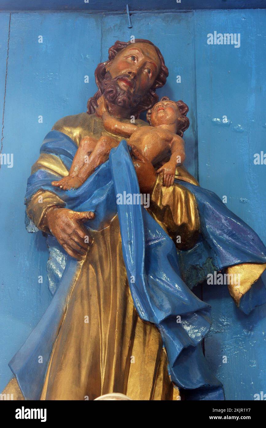 Saint Joseph holding the baby Jesus, statue on the Altar of Saint Joseph in the Parish Church of the Assumption of the Virgin Mary in Gornja Rijeka, C Stock Photo