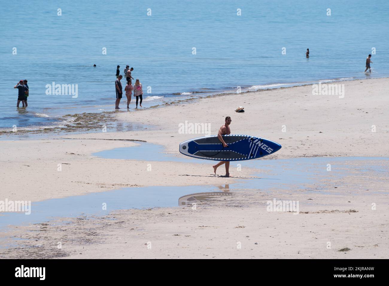 Adelaide, Australia. 25 November 2022.  A surfer walks with a surfboard parasol the hot weather at the beach in Adelaide Australia as temperatures are forecast to reach above 30celsius. Credit: amer ghazzal/Alamy Live News Stock Photo