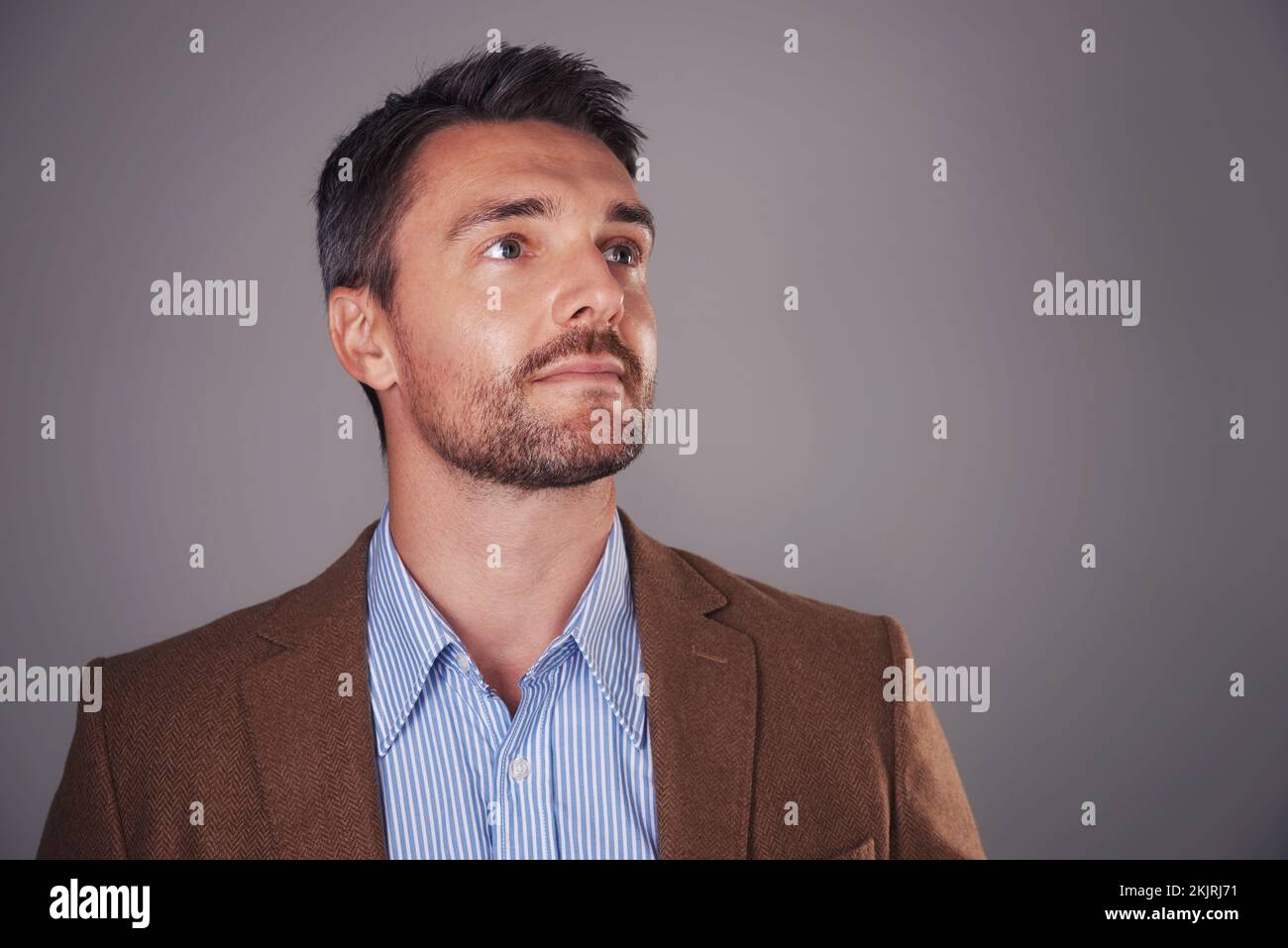 Looking ahead. Studio shot of a man deep in thought against a gray background. Stock Photo