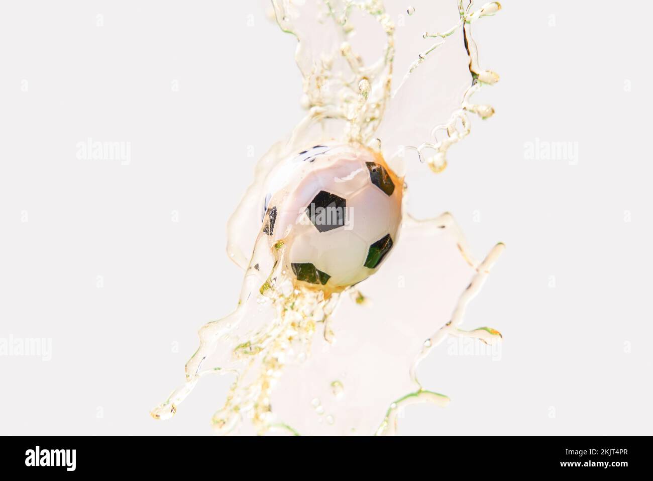 Soccer ball in beer splash on white background. Concept of soccer and