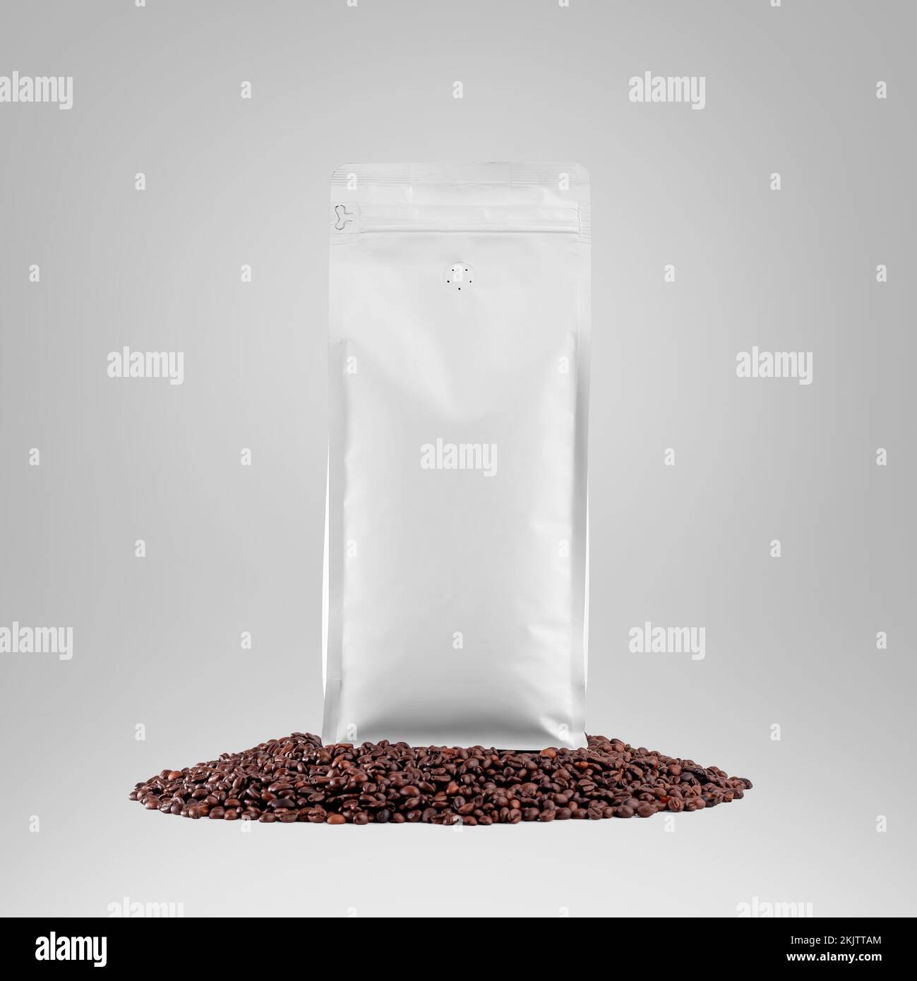 Mockup of a white bag standing on coffee beans, stabilo coffee pouch with space for design, branding, advertising. Package template with degassing val Stock Photo