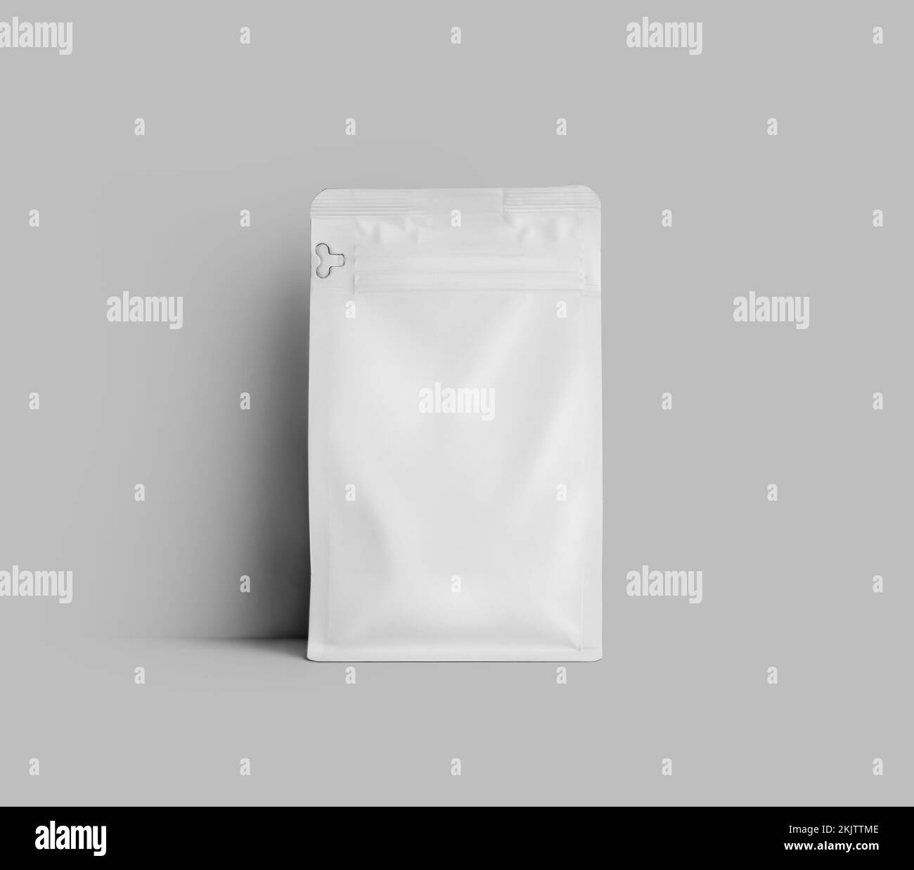Mockup of a white doy pack for coffee beans, standing near the wall, the package is isolated on the background. Tea pouch template, stabilo pack gusse Stock Photo