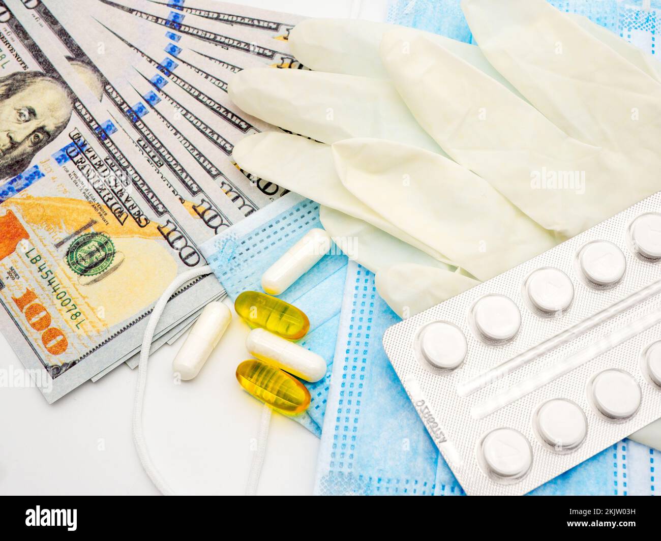 hundred dollars bills and medical supplies such as disposable face mask and gloves Stock Photo