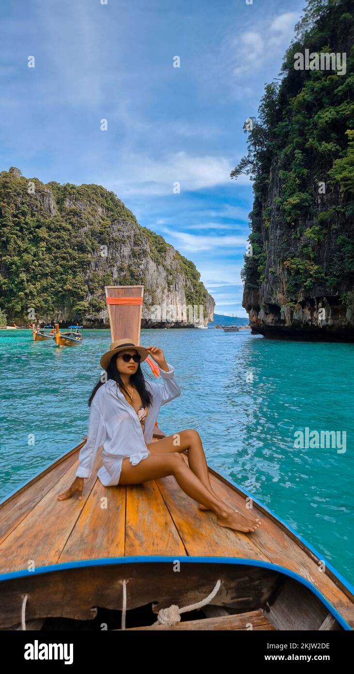 Asian Thai women in front of a Longtail boat at Pileh Lagoon Koh Phi Phi Thailand. Stock Photo