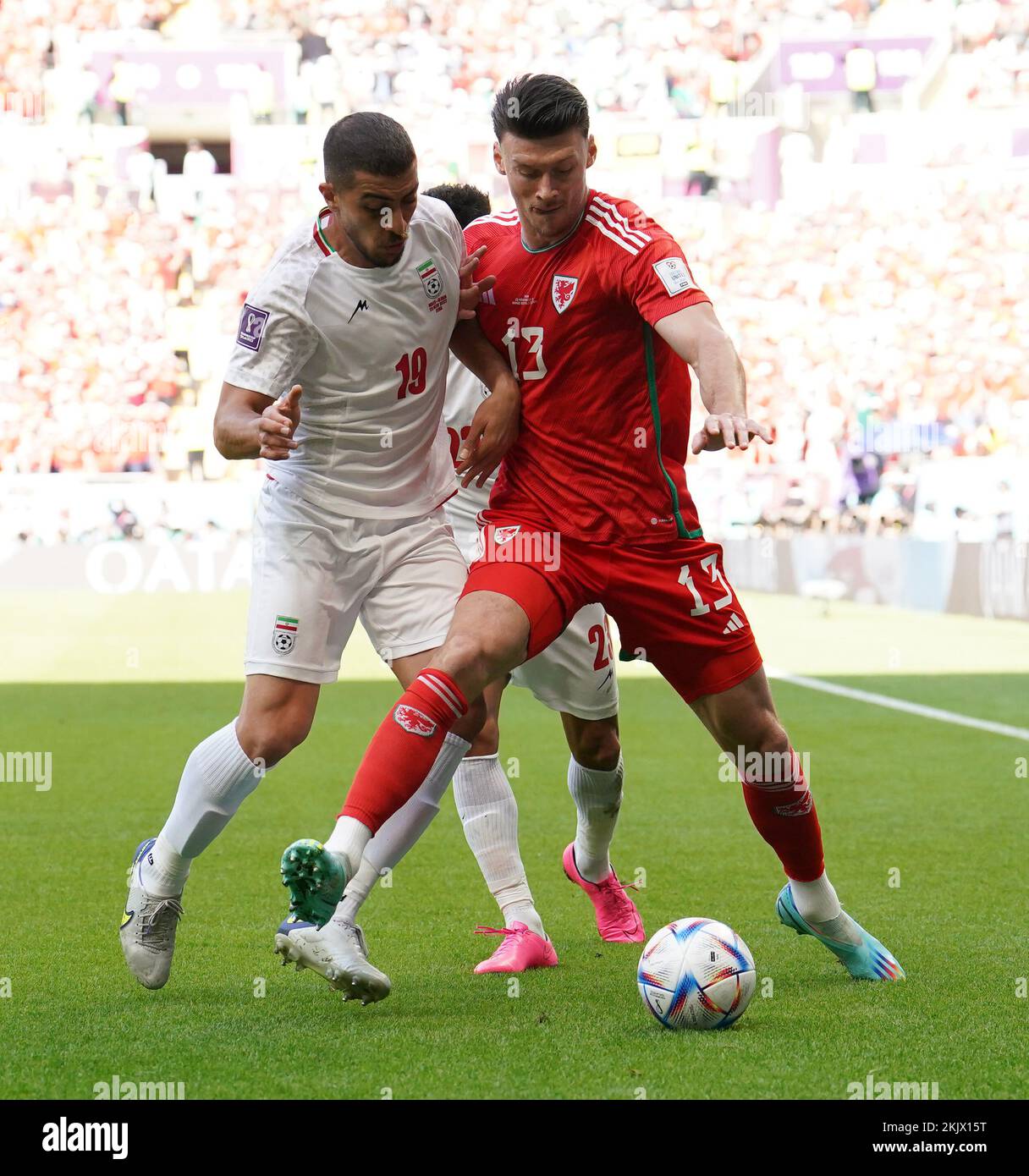 Iran's Majid Hosseini (left) and Wales' Kieffer Moore battle for the ball during the FIFA World Cup Group B match at the Ahmad Bin Ali Stadium, Al-Rayyan. Picture date: Friday November 25, 2022. Stock Photo