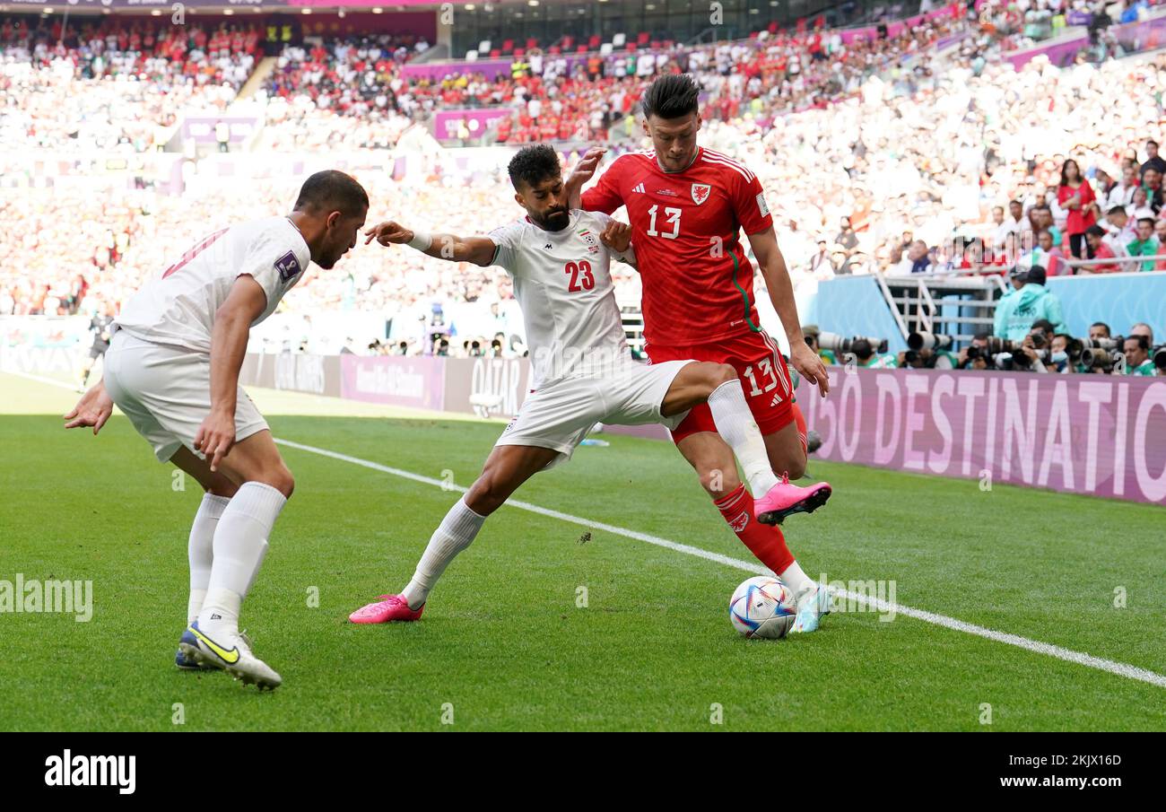 Iran's Ramin Rezaeian (centre) and Wales' Kieffer Moore battle for the ball during the FIFA World Cup Group B match at the Ahmad Bin Ali Stadium, Al-Rayyan. Picture date: Friday November 25, 2022. Stock Photo