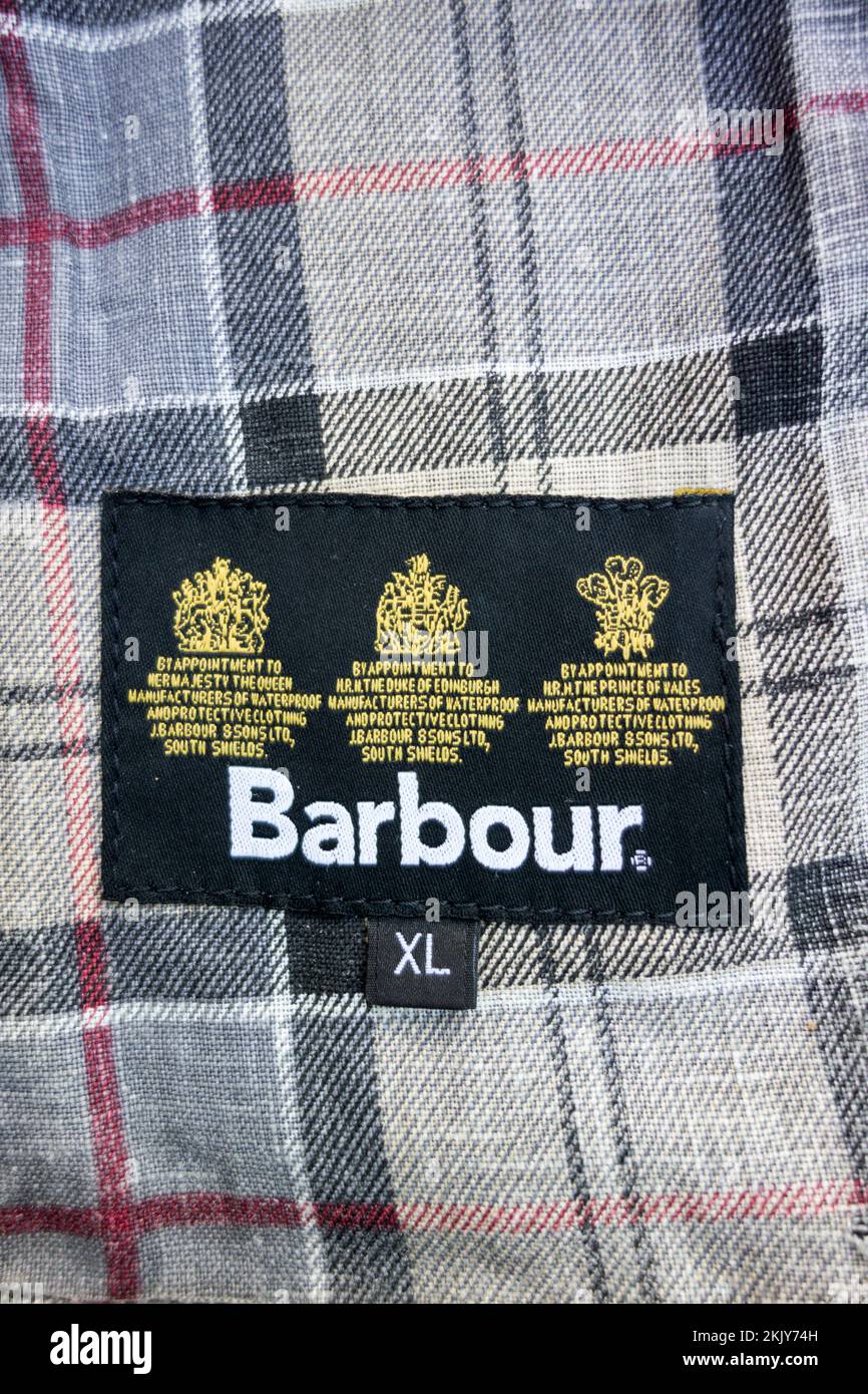 Closeup of Barbour Dress Tartan lining and By Appointment to Her Majesty the Queen Royal crest stitched inside a Barbour Waxed jacket Stock Photo