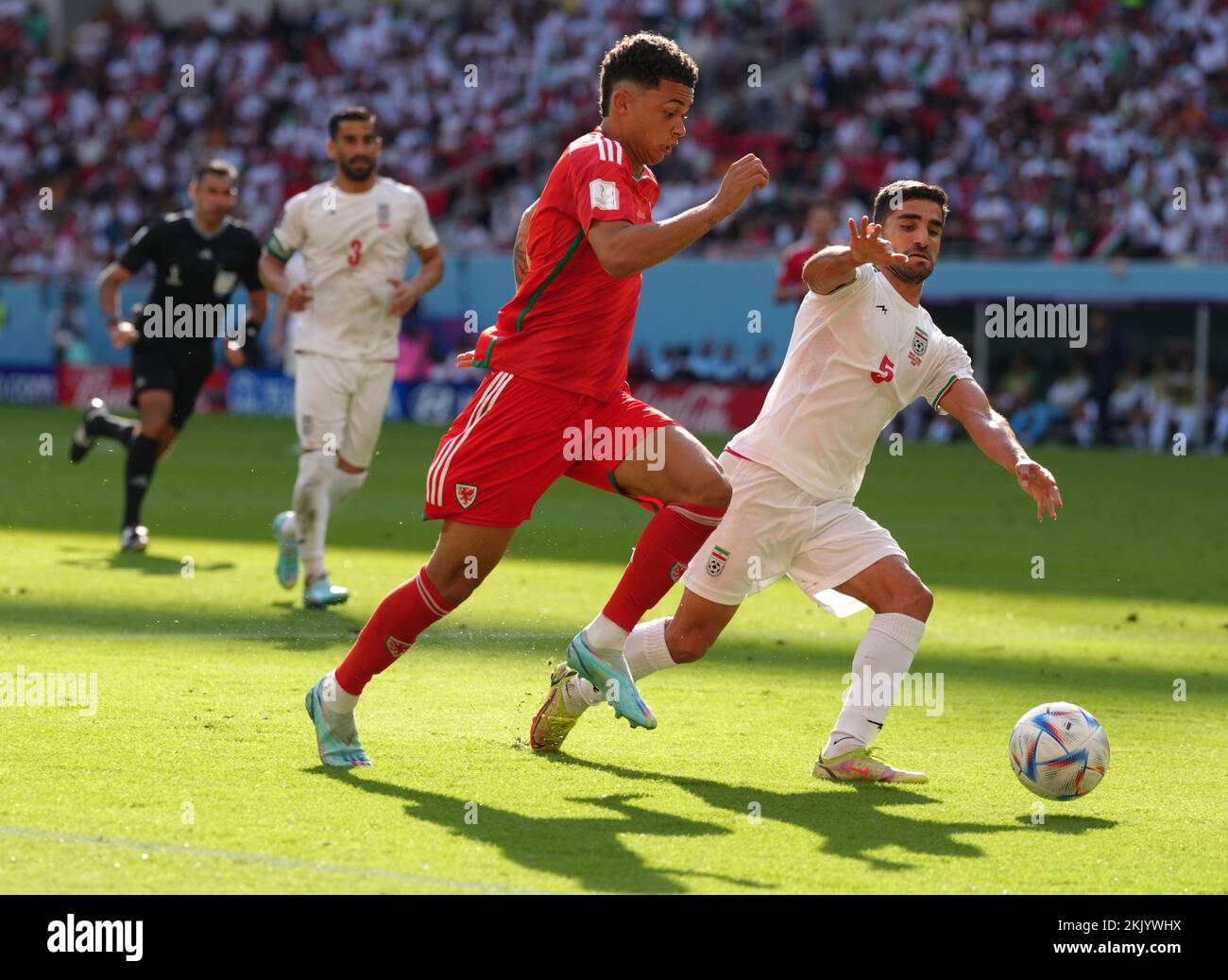Wales' Brennan Johnson (left) and Iran's Milad Mohammadi during the FIFA World Cup Group B match at the Ahmad Bin Ali Stadium, Al-Rayyan. Picture date: Friday November 25, 2022. Stock Photo