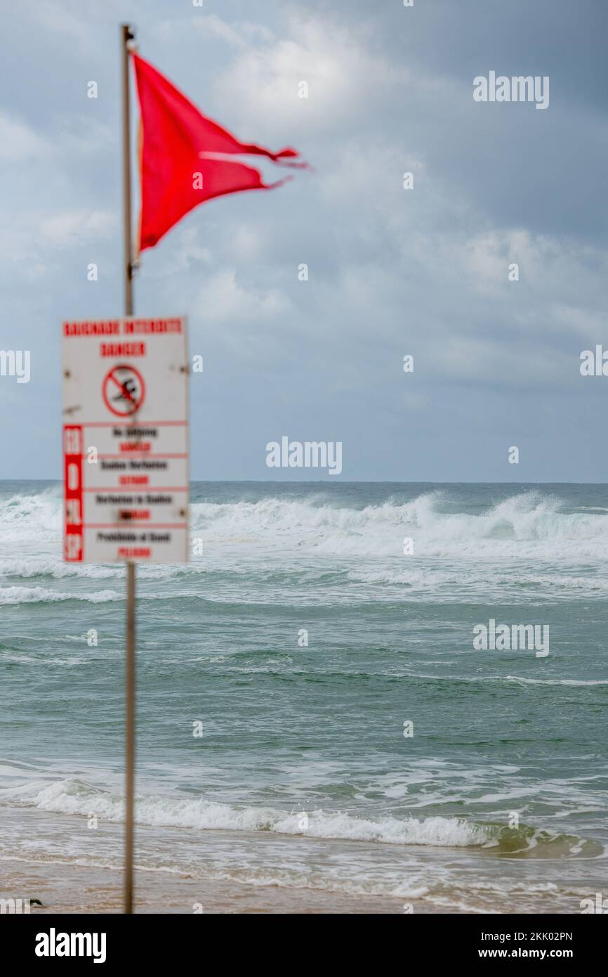 Danger Red Flags fly on the beach as rough seas break waves up the shoreline, Minizan, France