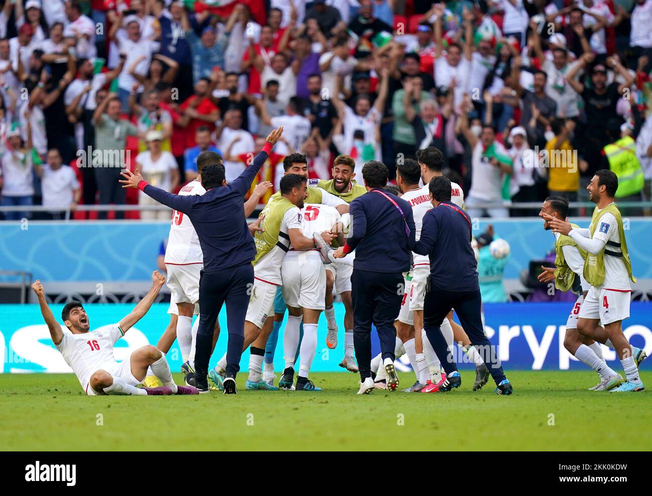 Iran players and coaching staff celebrate on the pitch after Roozbeh Cheshmi scores their side's first goal of the game during the FIFA World Cup Group B match at the Ahmad Bin Ali Stadium, Al-Rayyan. Picture date: Friday November 25, 2022. Stock Photo