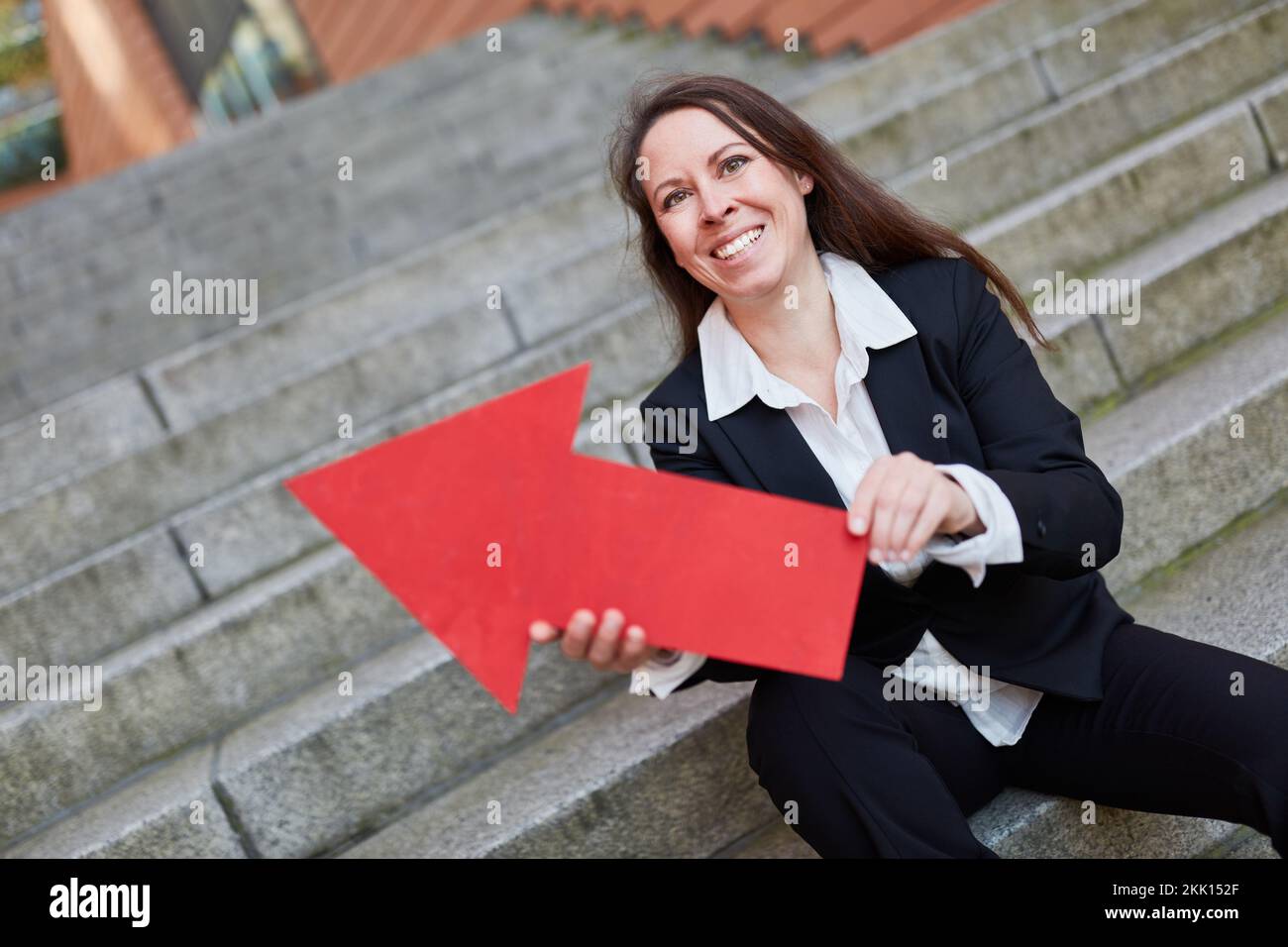 Successful businesswoman holding red arrow sign as sucess and career symbol Stock Photo