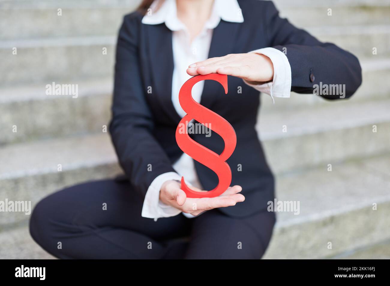 Female hands holding red paragraph sign as justice and law concept Stock Photo