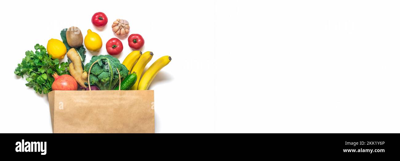 Eco friendly paper shop bag with raw organic green vegetables isolated on white background Flat lay, top view Zero waste, plastic free concept Healthy Stock Photo