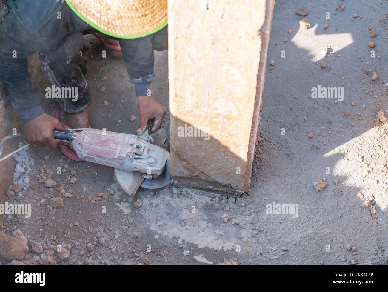 Worker use saw grinding machine cut foundation pile at the construction site. Stock Photo