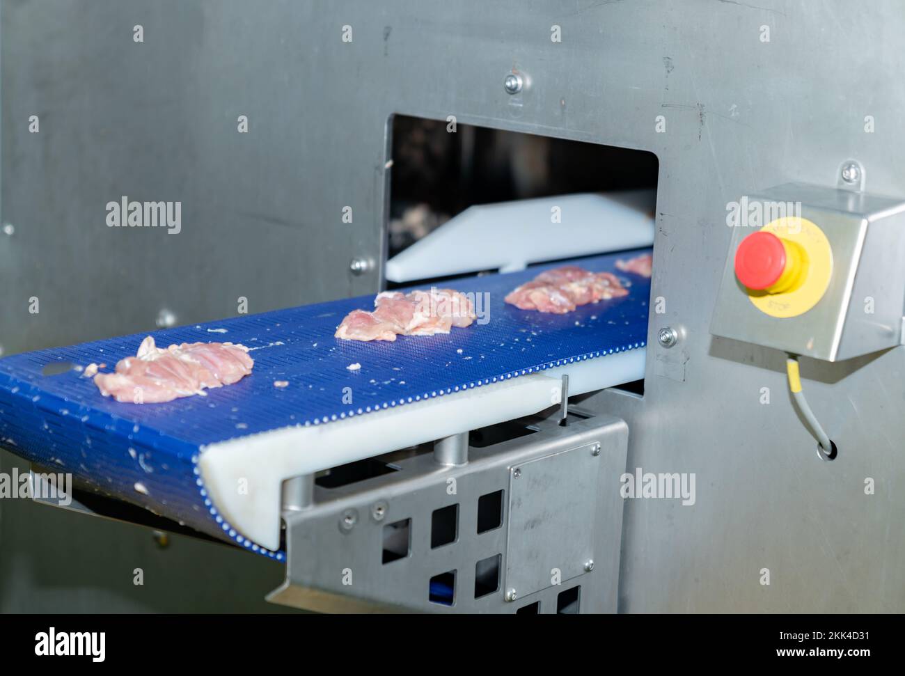 Close up chicken meat load out from auto cutting size machine in