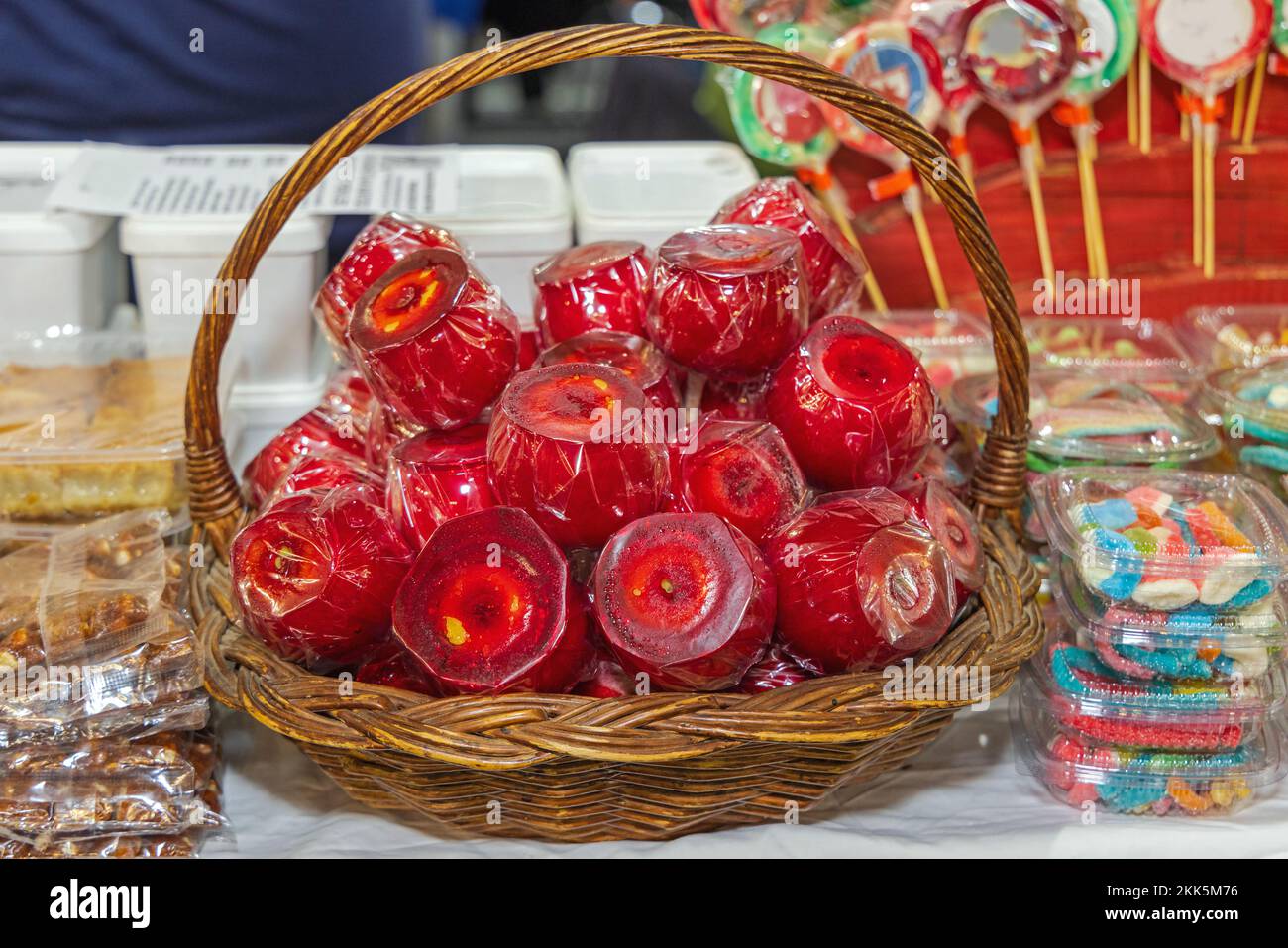 Whole Red Candy Apples Covered in Sugar Coating in Basket at Fall Festival Stock Photo
