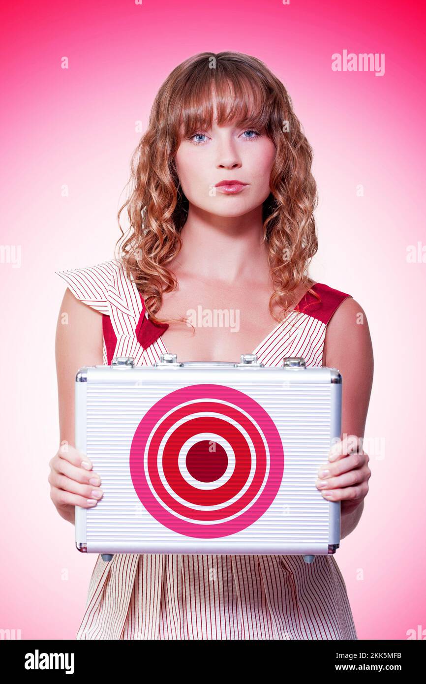 Beautiful business woman holding briefcase with target symbol in a depiction of aim, ambition