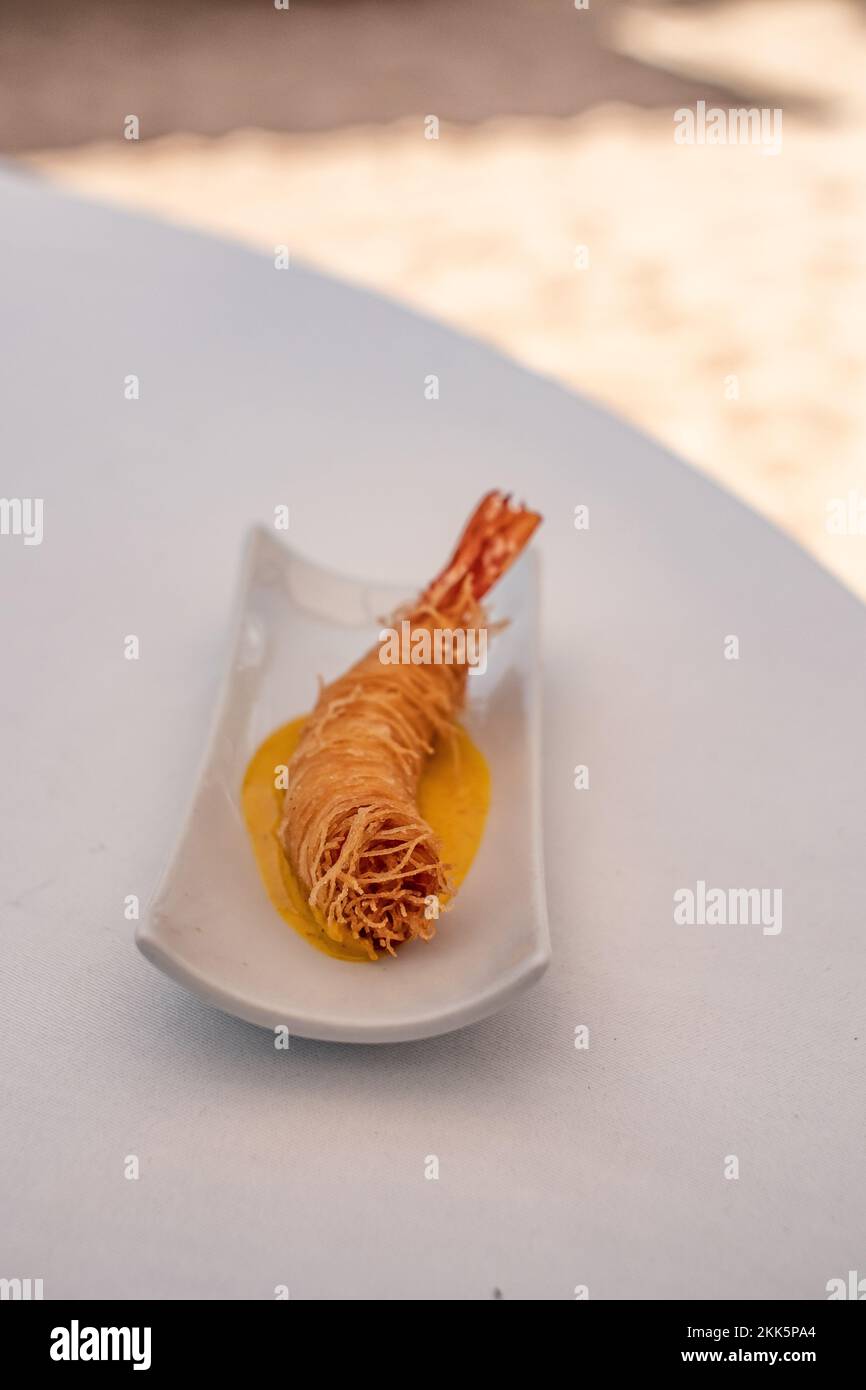 A vertical shot of a gamba in a white plate in the restaurant Stock Photo