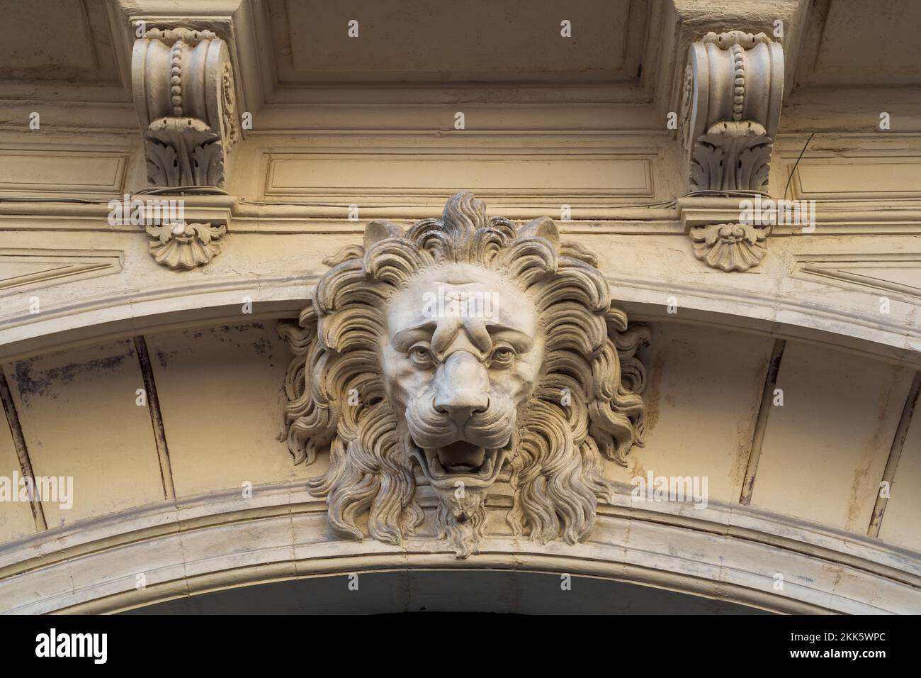 Beautiful stucco lion head decor on ancient building entrance porch in