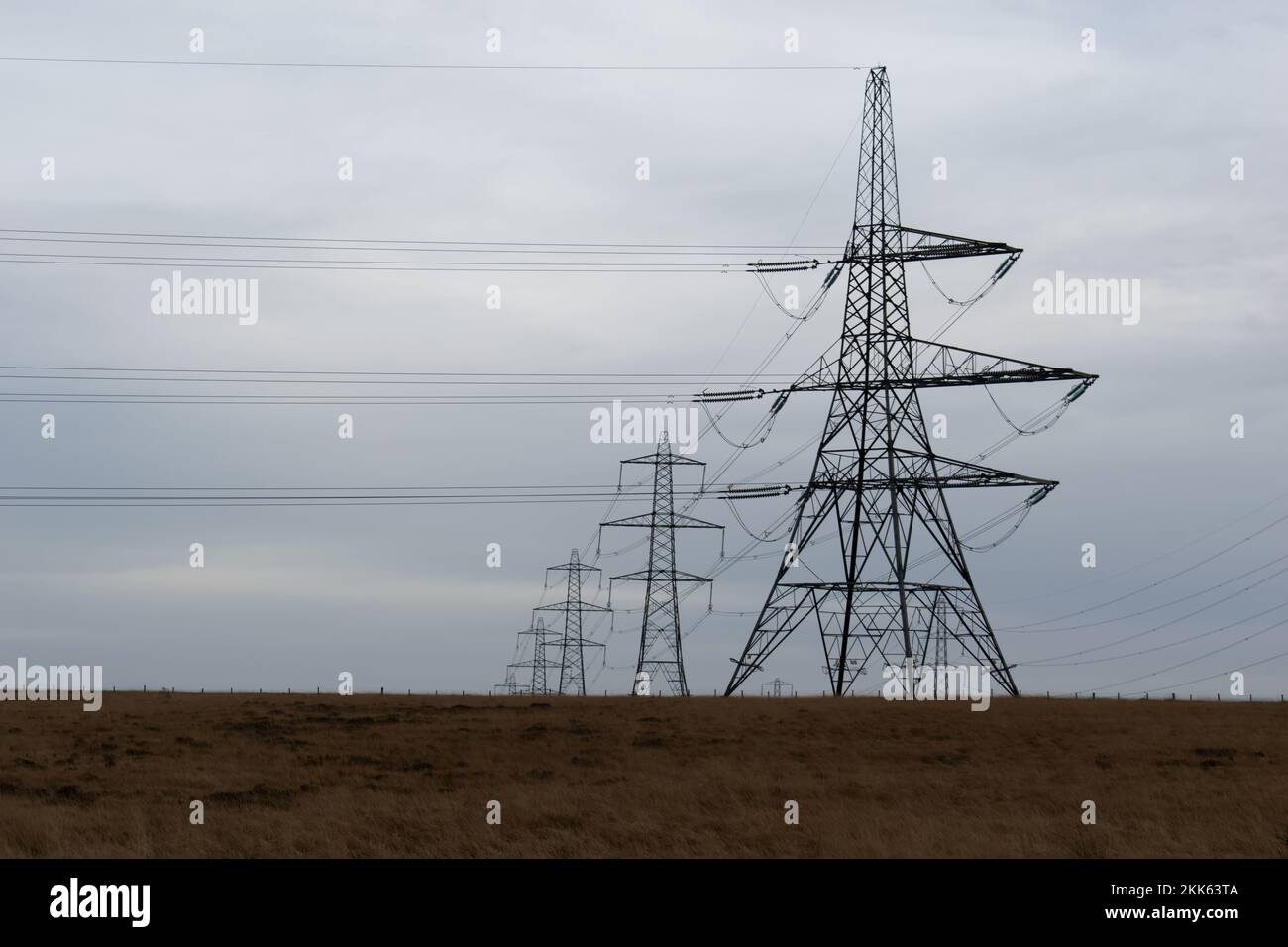 Row of electricity pylons on a Yorkshire moor. Copy space left. Stock Photo
