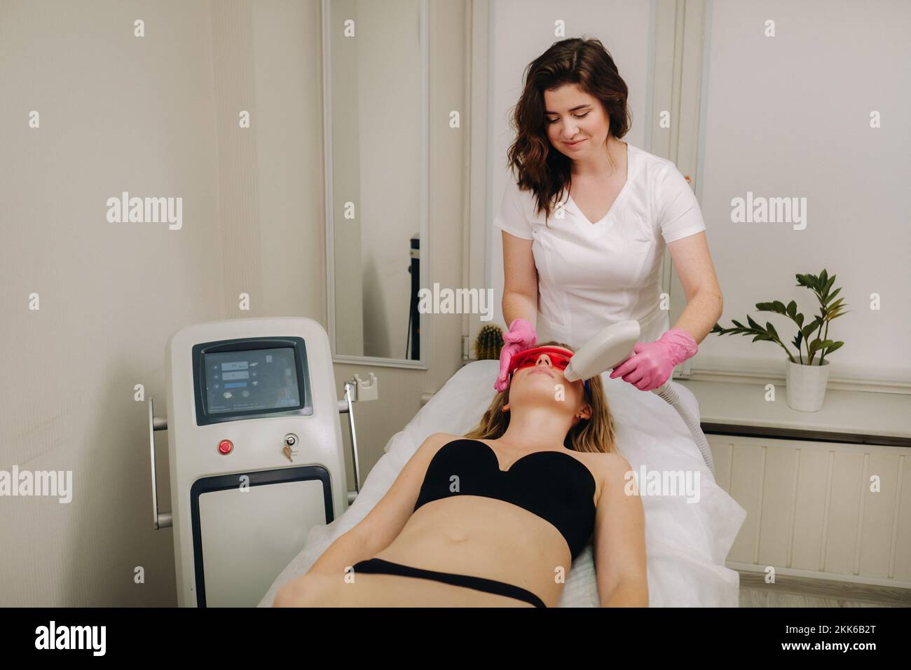 A doctor does laser hair removal for a client of unwanted facial hair