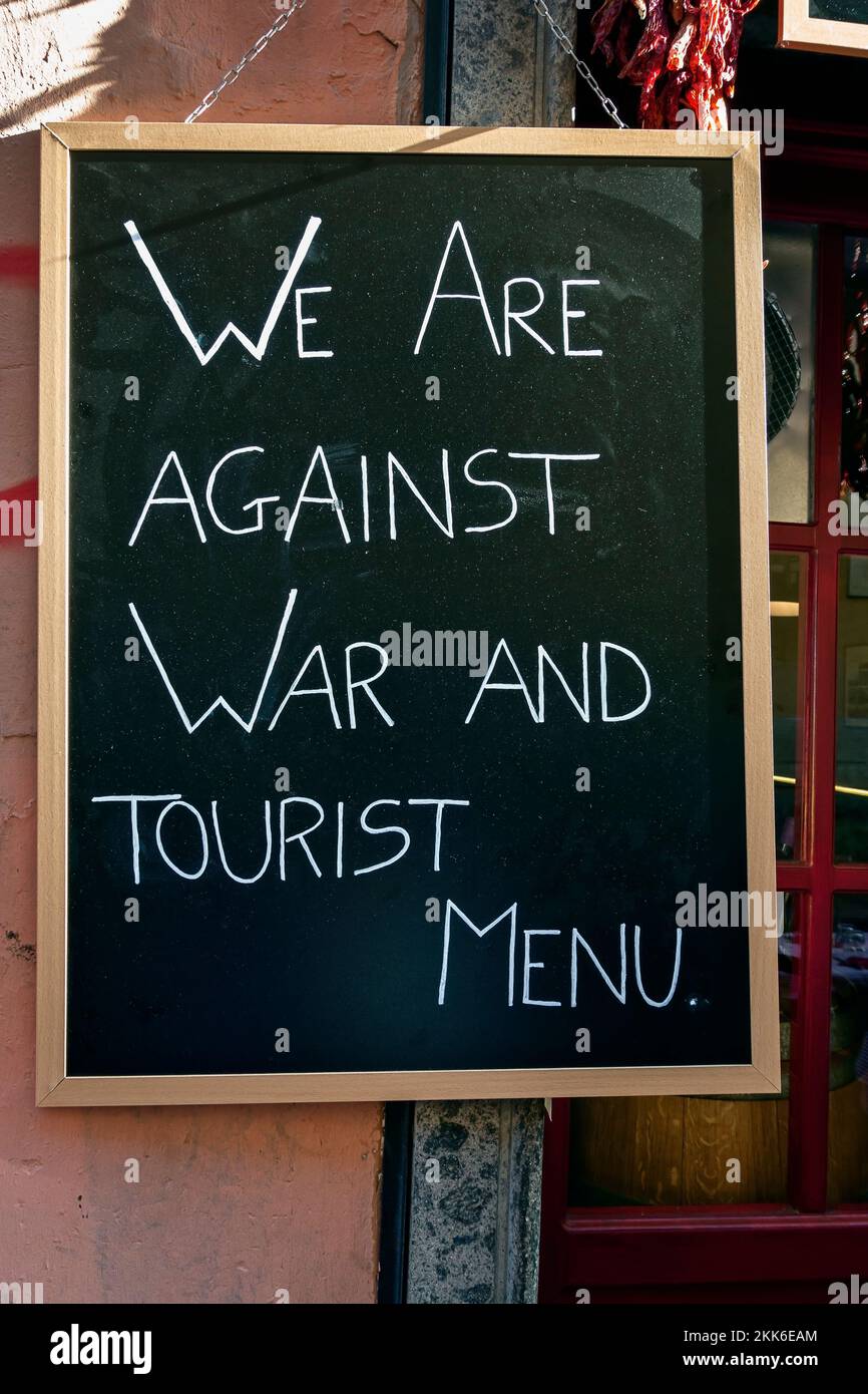 We are against war and tourist menu. Concept ironic peace message against war, on a blackboard, sign outside a restaurant in Rome, Italy, Europe, EU. Stock Photo