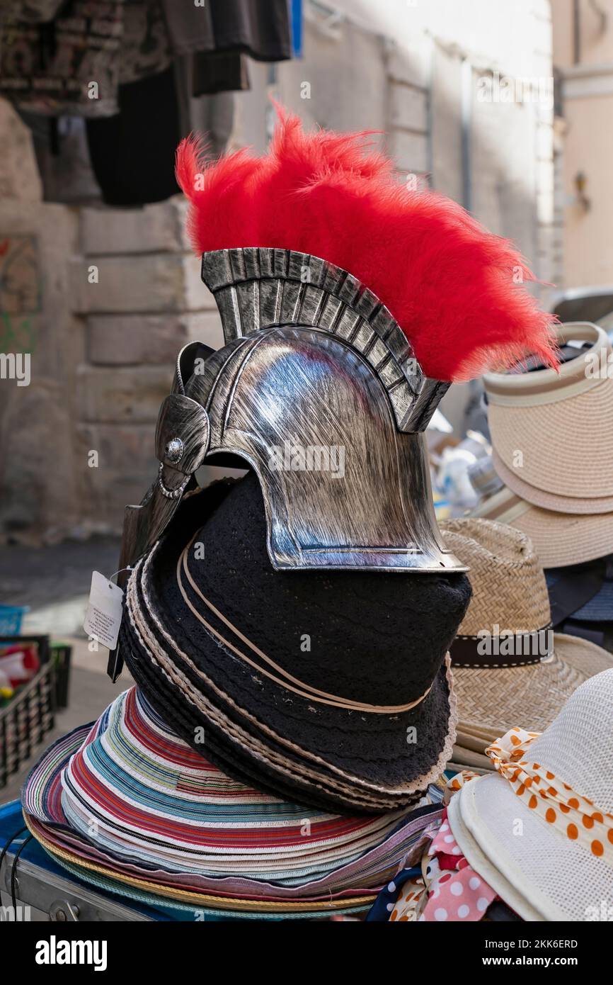Roman helmet with red feathers, as a souvenir on display for sale in a souvenir hats stall. Rome, Italy, Europe, European Union, EU Stock Photo
