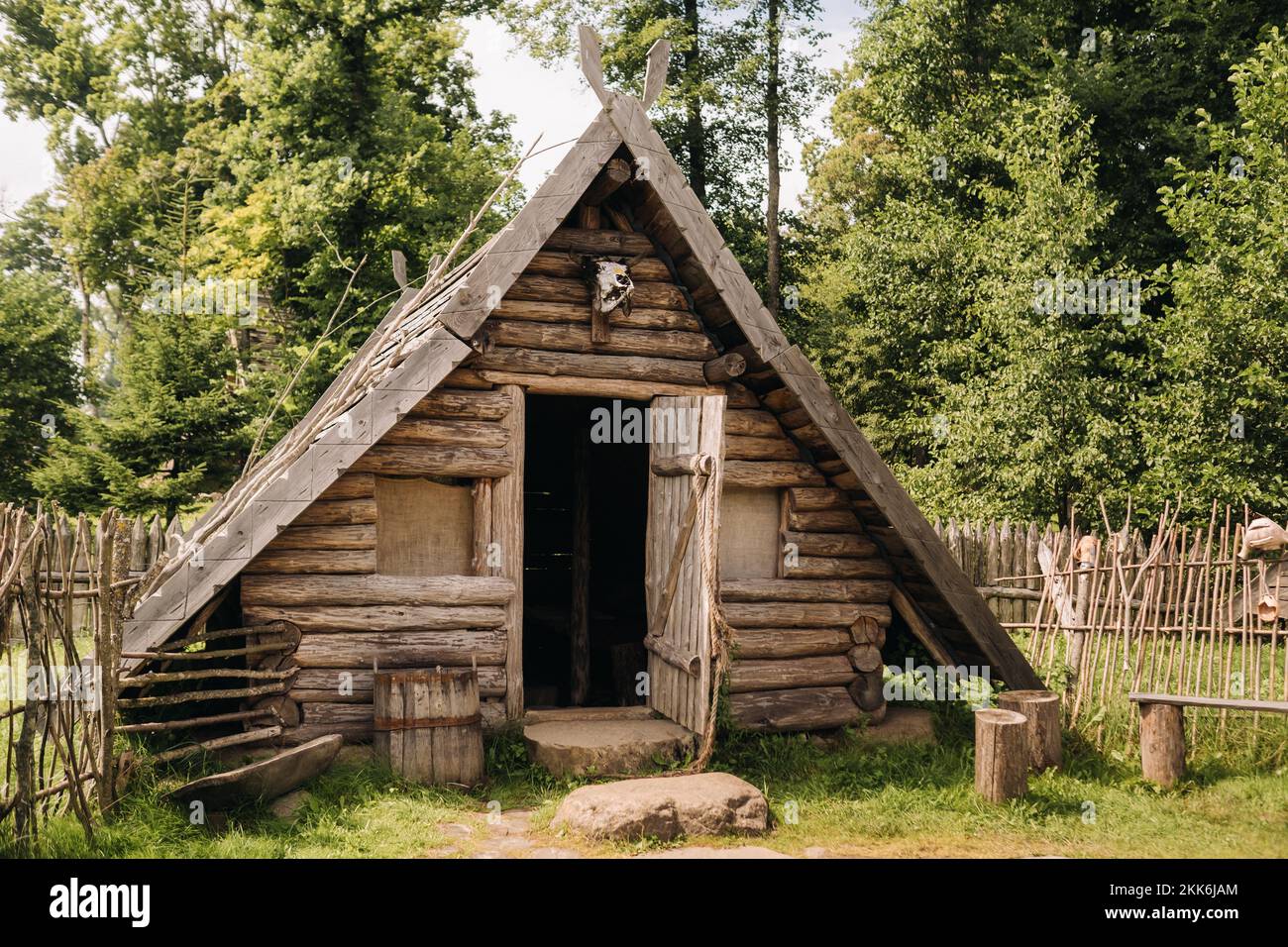 Triangular Logentry Triangular log houses with wooden roofs behind a fence. Montenegro ...