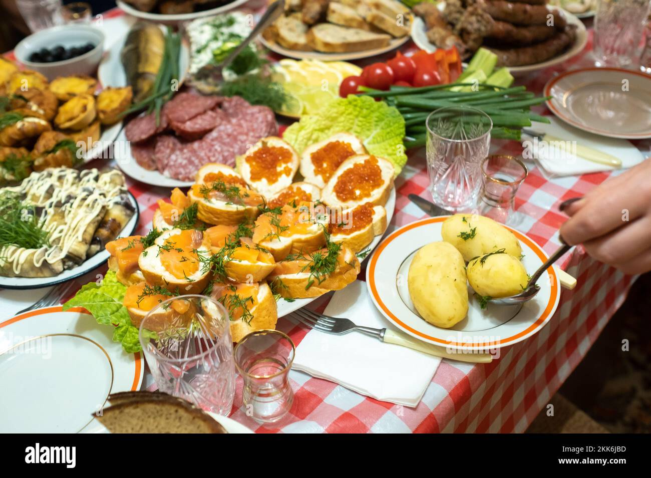 A lot of different food on the Banquet table and served boiled potatoes with dill.A large number of ready-made dishes on the table.Holiday at the Stock Photo