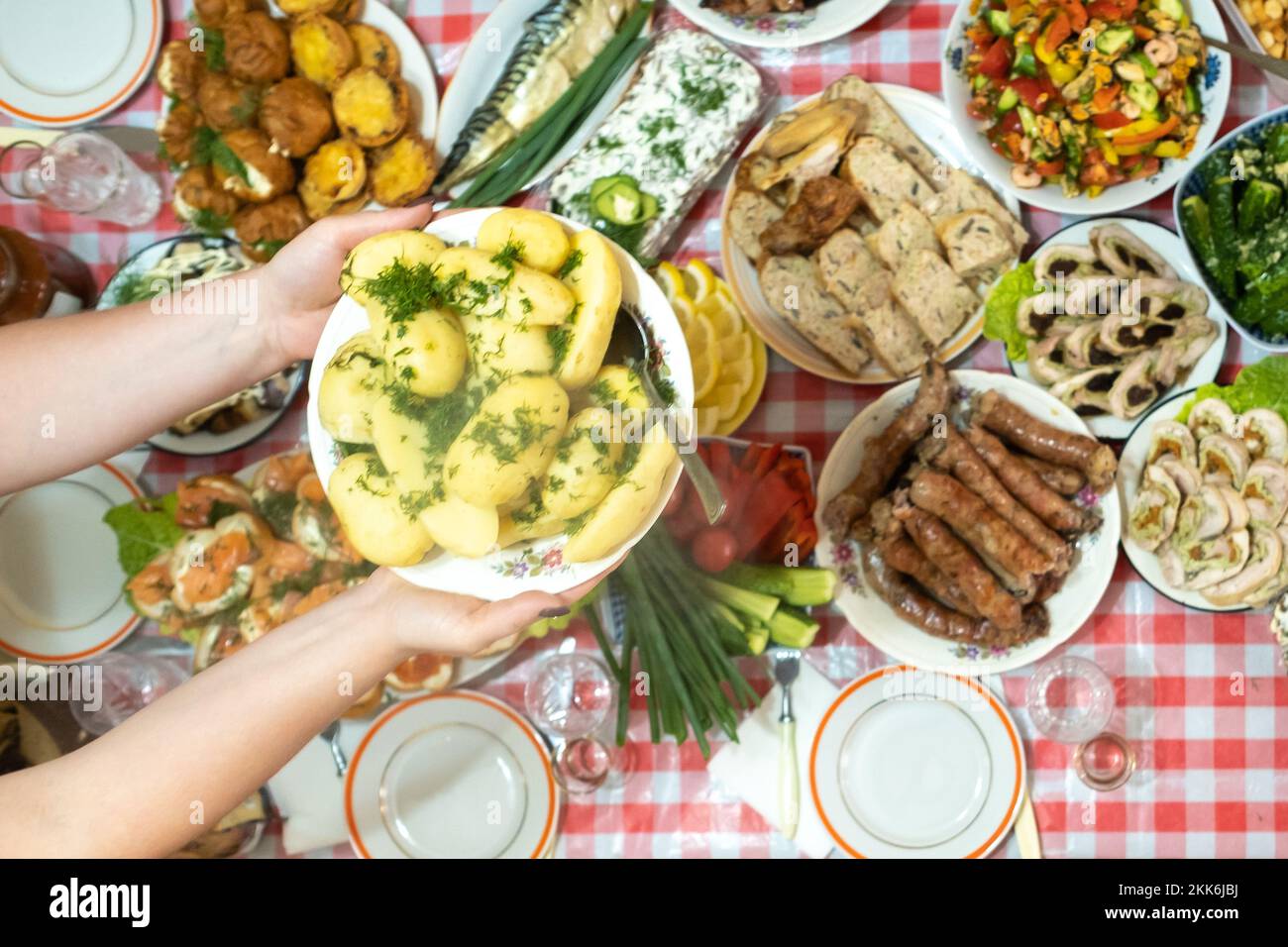 A lot of different food on the Banquet table and served boiled potatoes with dill.A large number of ready-made dishes on the table.Holiday at the Stock Photo