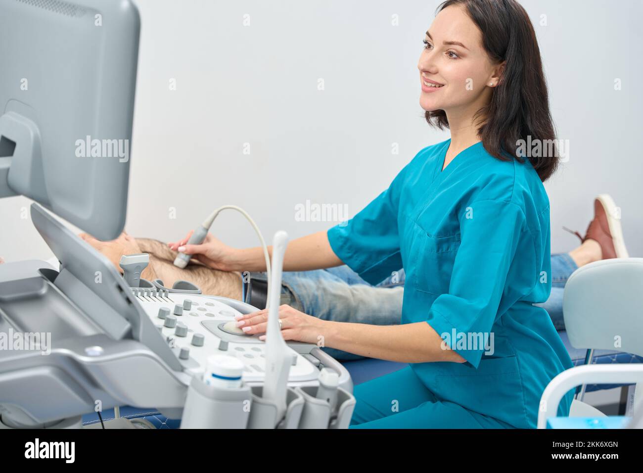 Woman performs an ultrasound examination of abdominal organs of man Stock Photo