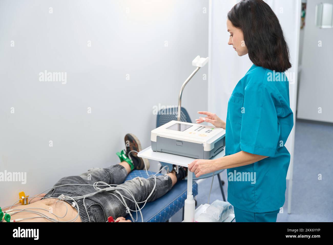 Nurse is making cardiograph settings before the procedure on cabinet Stock Photo