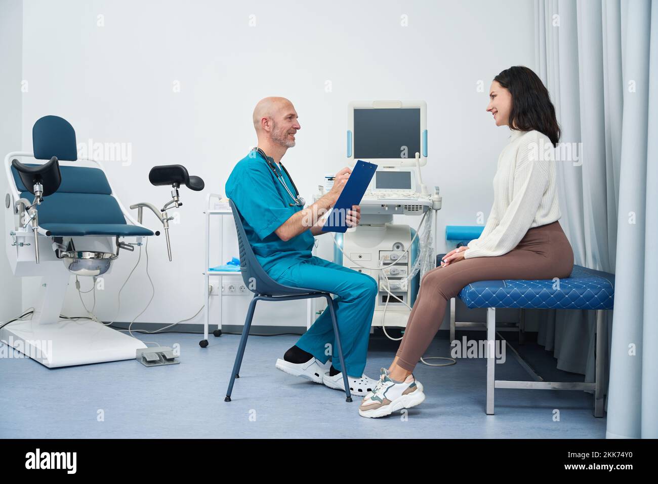 Doctor and patient sit opposite each other in gynecological cabinet Stock Photo