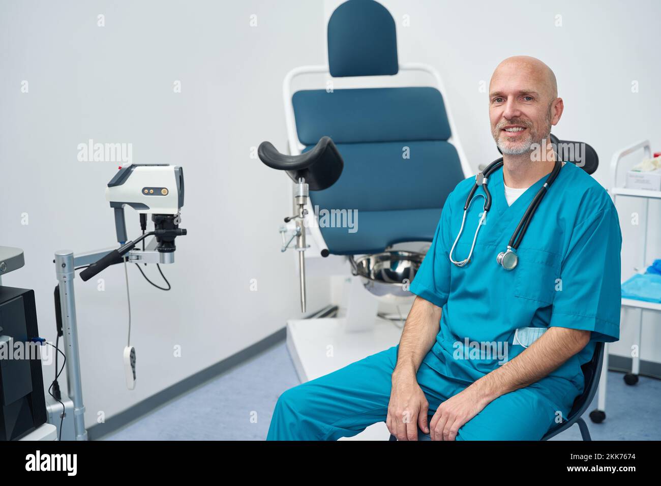 Doctor in medical uniform is next to gynecological examination chair Stock Photo