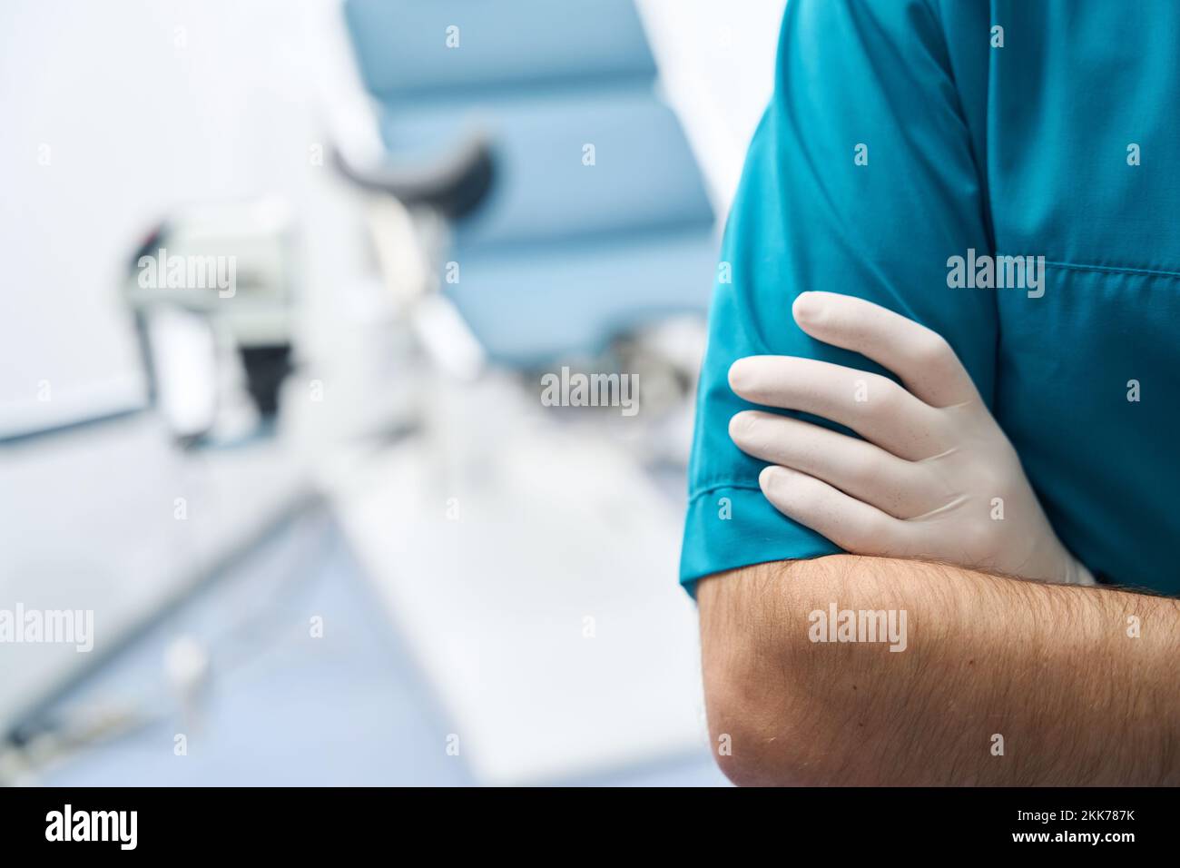 Man folded arms on chest against background of gynecological chair Stock Photo