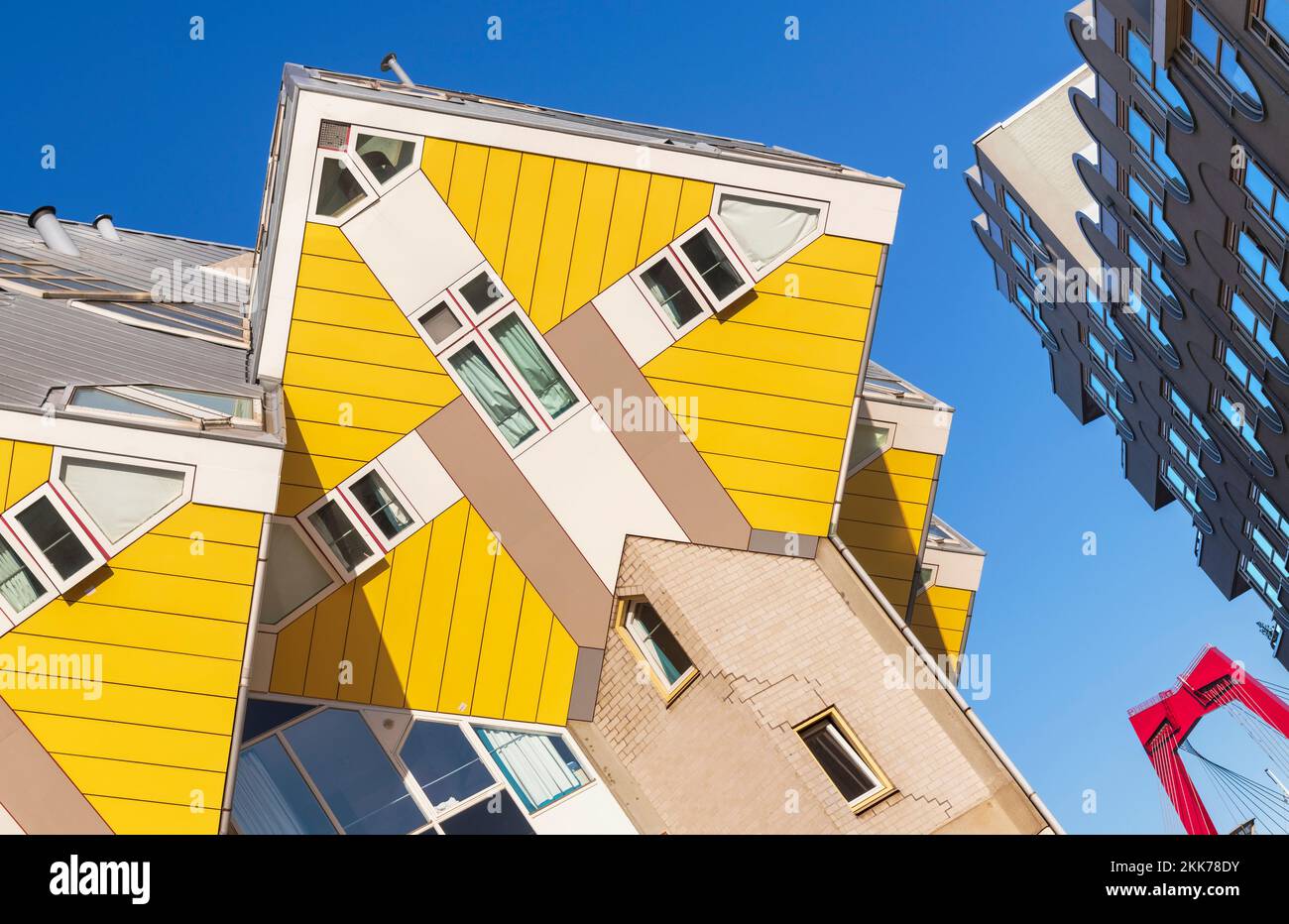 Holland, Rotterdam, The Cube Houses, an innovative housing development where each house is a cube tilted over by 45 degrees, designed by Dutch architect Piet Blom and bult between 1977 and 1984, angular view with apartment block and Willemsbrug or William's Bridge in the background. Stock Photo
