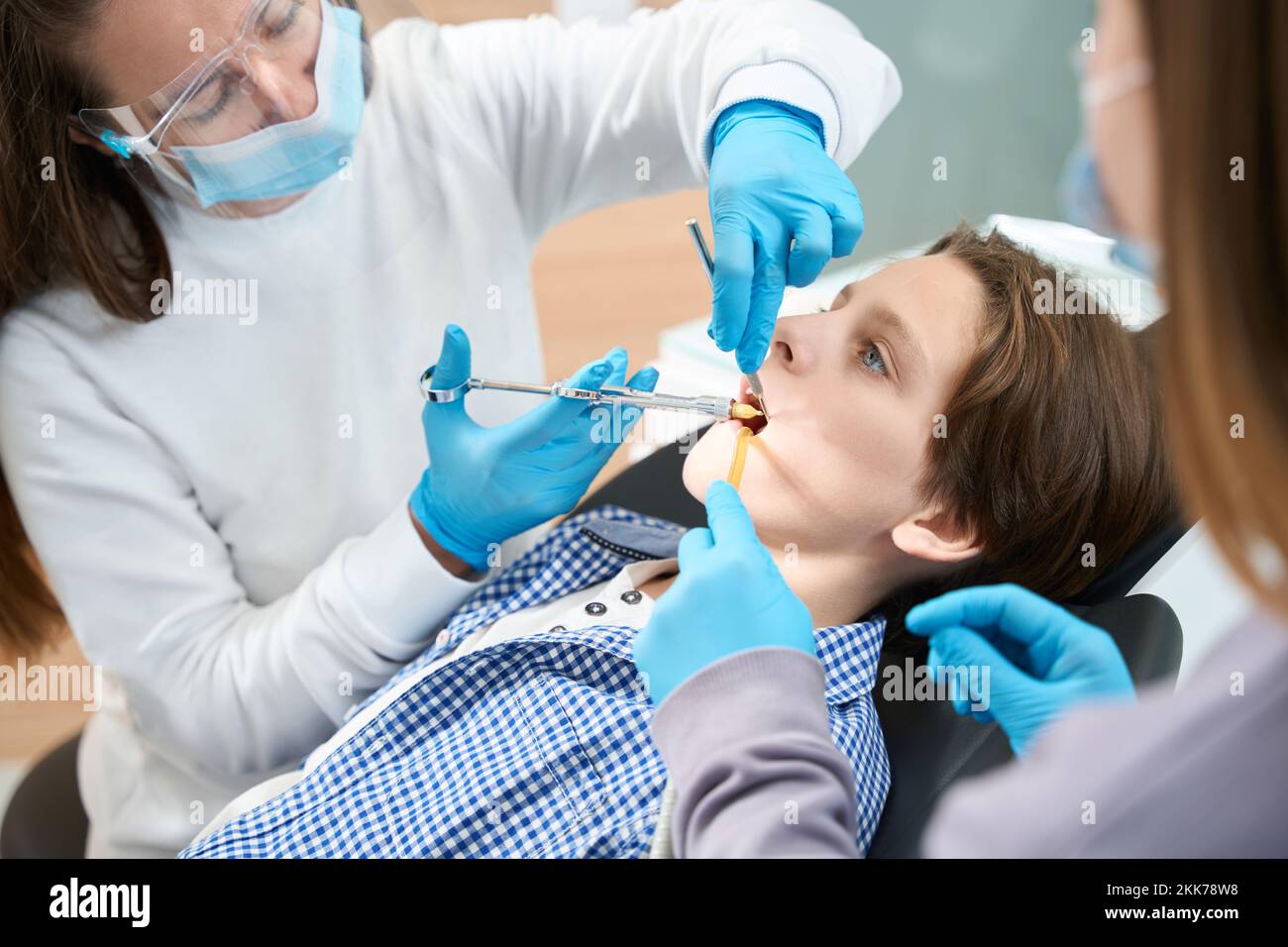 Child is given an injection of anesthesia before tooth extraction Stock