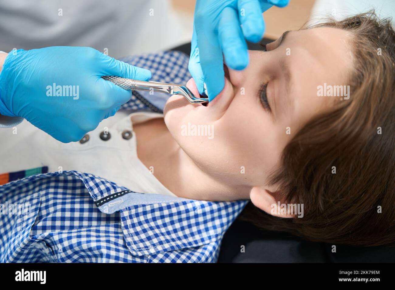 Boy is having a tooth removed in a dental clinic Stock Photo