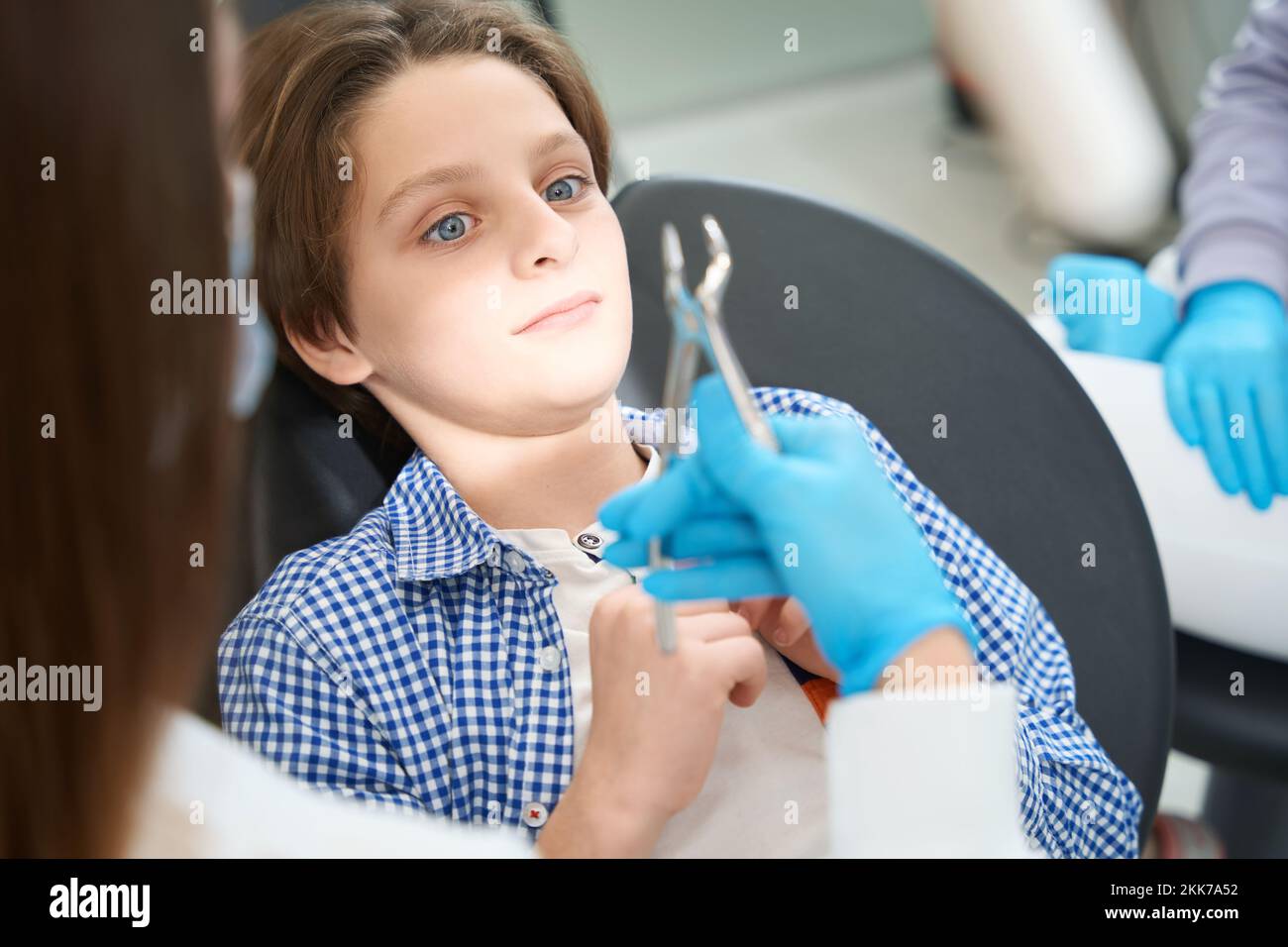 Frightened young patient in a chair at the dentist Stock Photo
