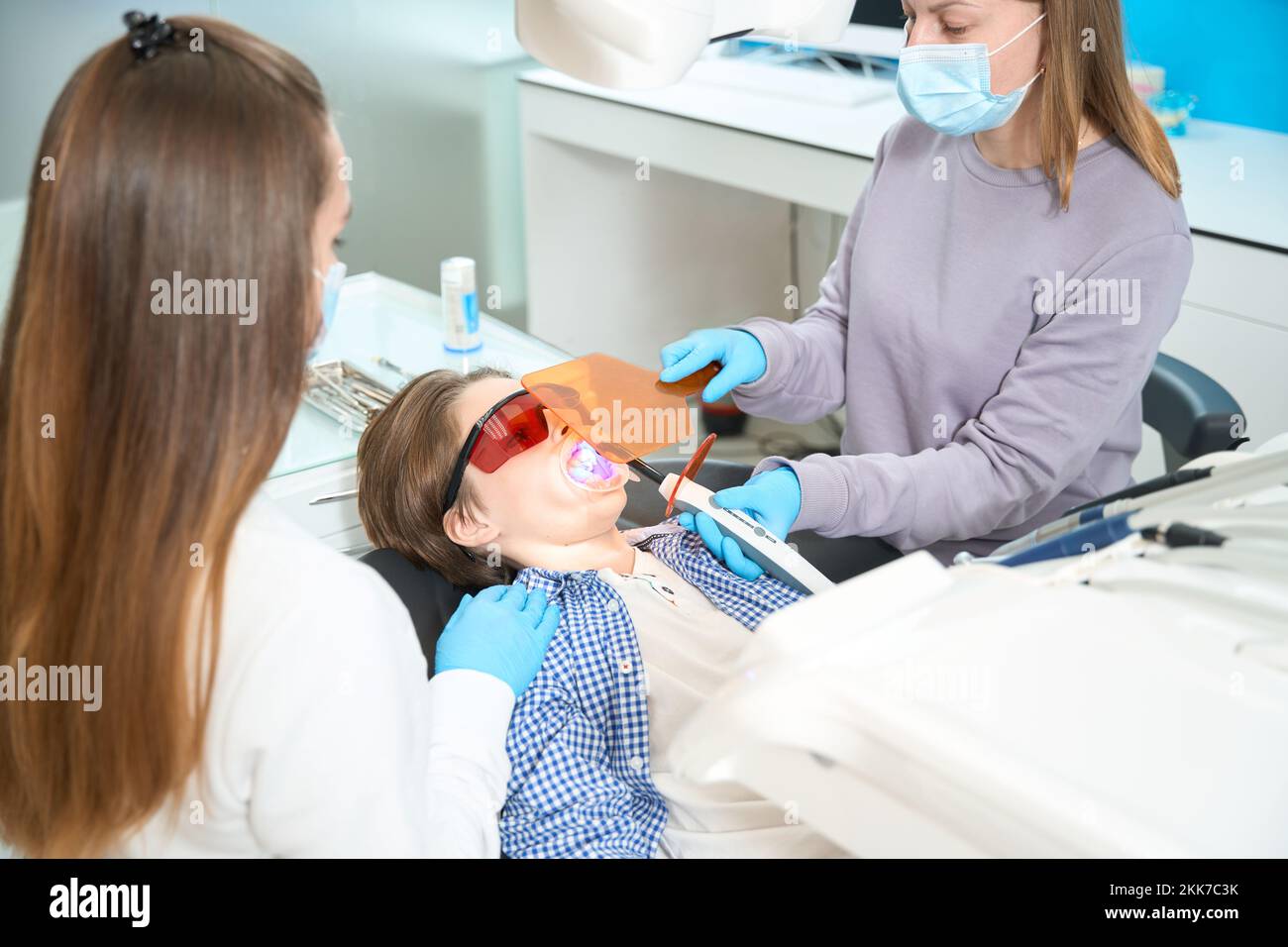 Boy in special protective glasses lies in a dental chair Stock Photo