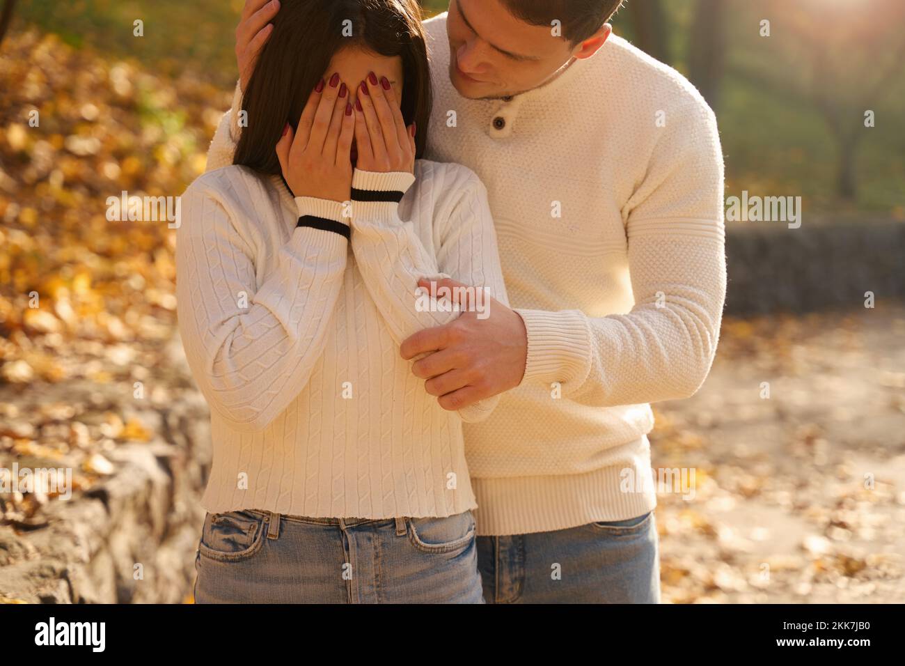 Guy gently comforts a crying girlfriend in a city park Stock Photo