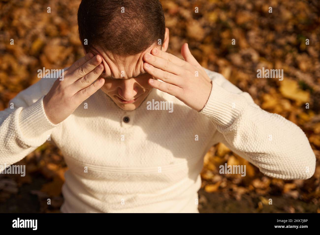 Man is in pain and holding his forehead Stock Photo