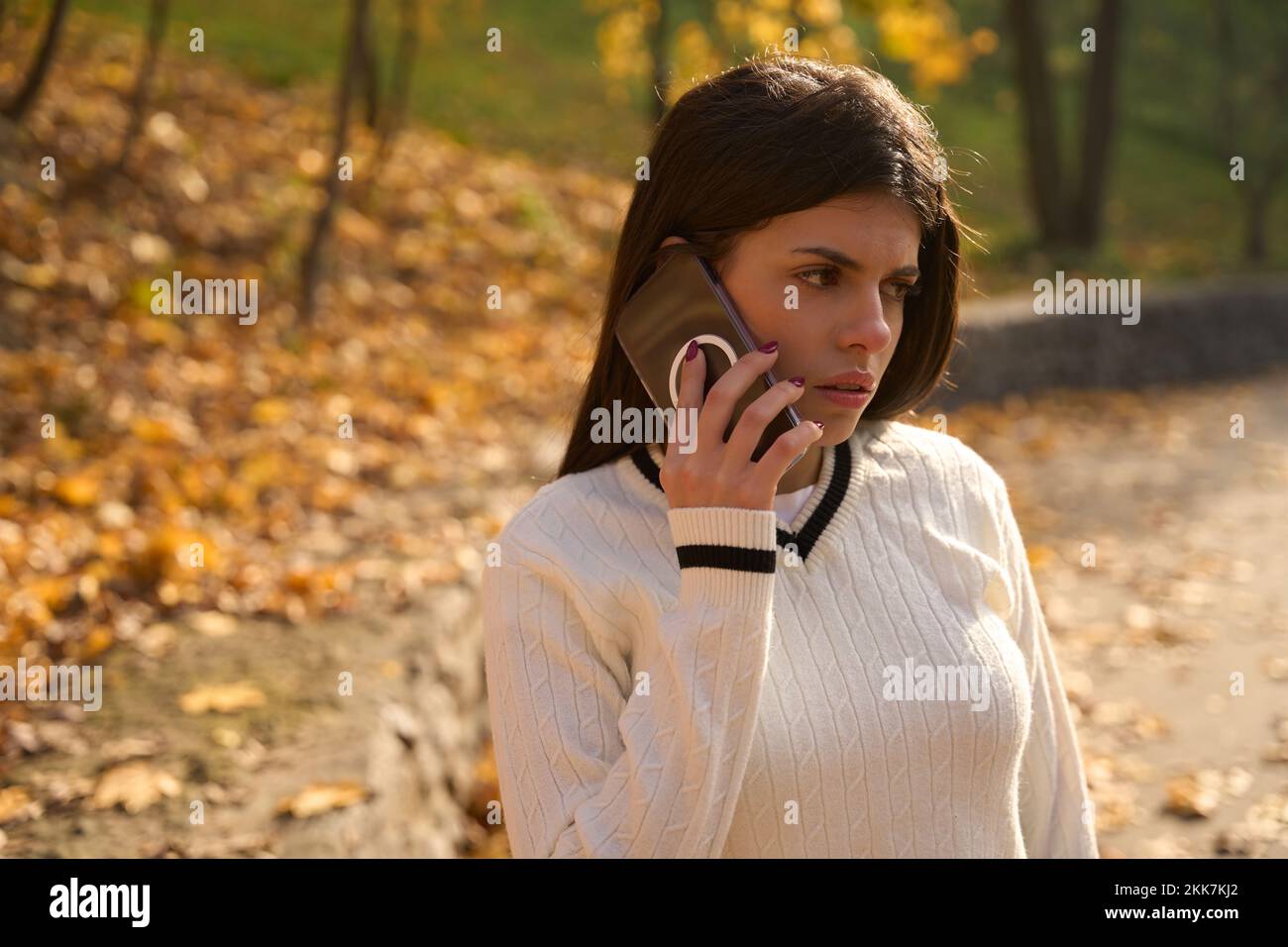 Sad young woman holding a phone near her ear Stock Photo