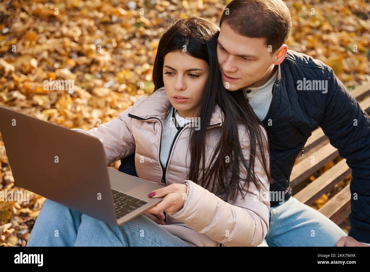Guy with his girlfriend is browsing something in a laptop Stock Photo