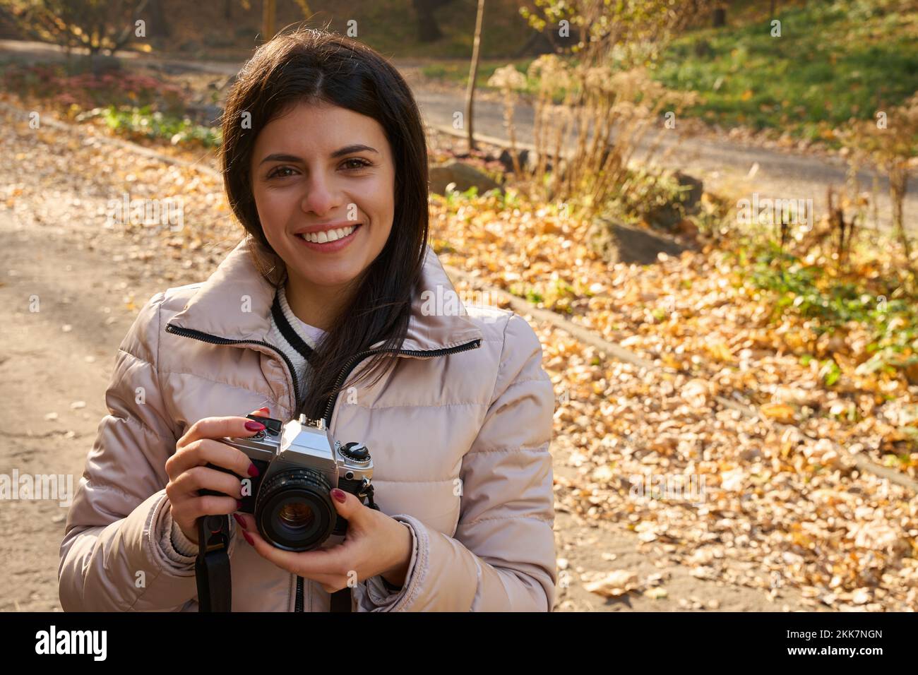 Shot of smiling young woman with camera in her hands Stock Photo