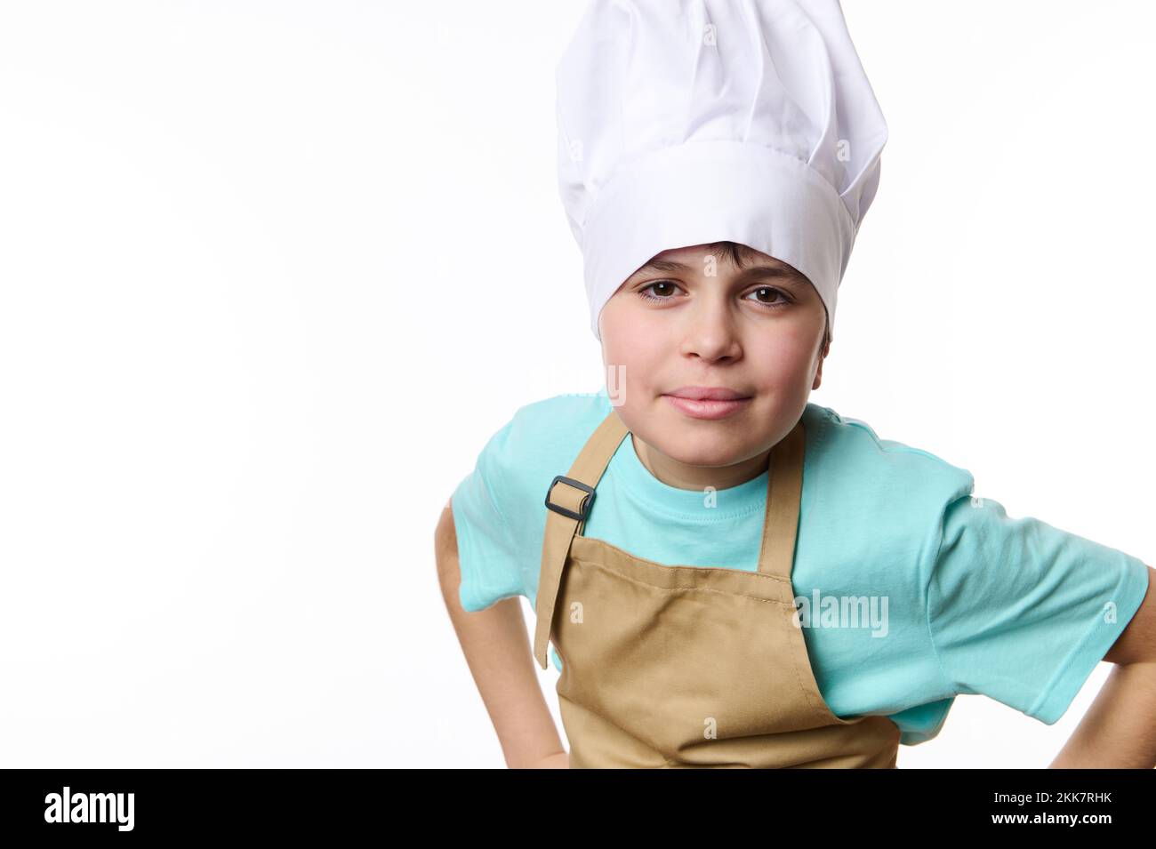 Isolated portrait on white of a teenager wearing chef hat and apron